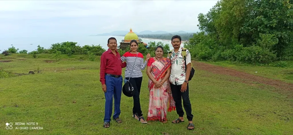 Family enjoying scenic hilltop view over Gokarna coastline and temple shrine